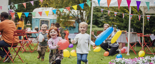 children running with balloons at a community event